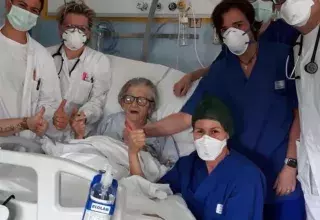 Les soignants fiers posent aux côté de la grand-mère qui a vaincu le coronavirus