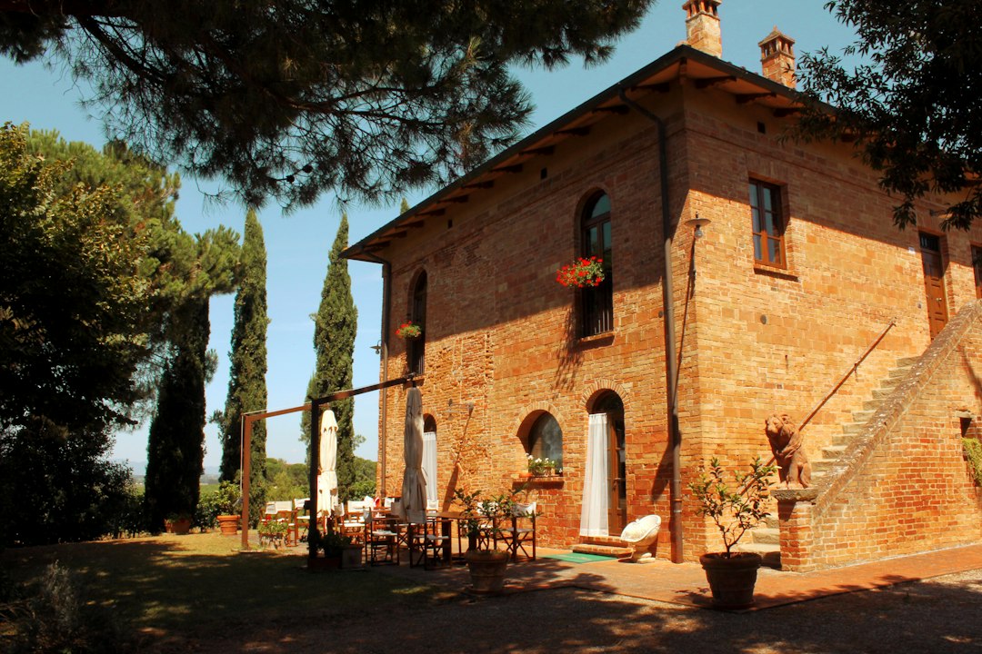 Maison ancienne en brique entourée d'arbres à la campagne