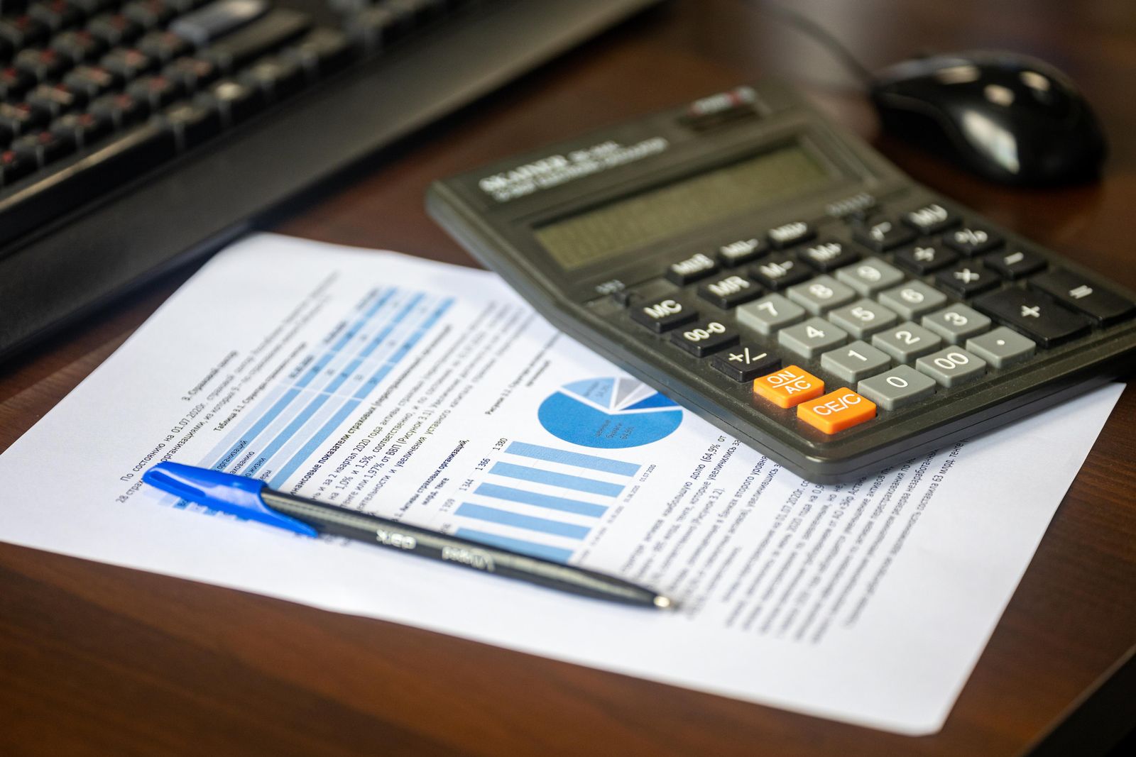 Calculatrice, stylo et document financier avec graphiques sur un bureau