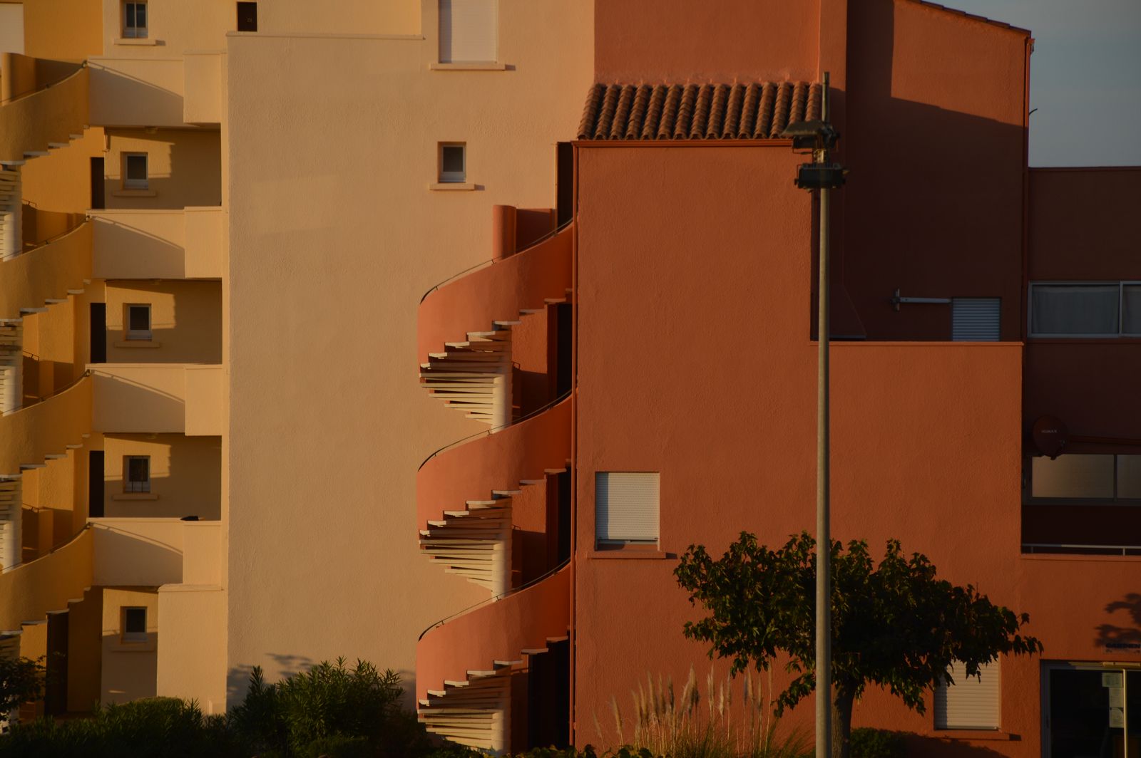 Façade ocre d’un immeuble résidentiel avec escaliers en colimaçon