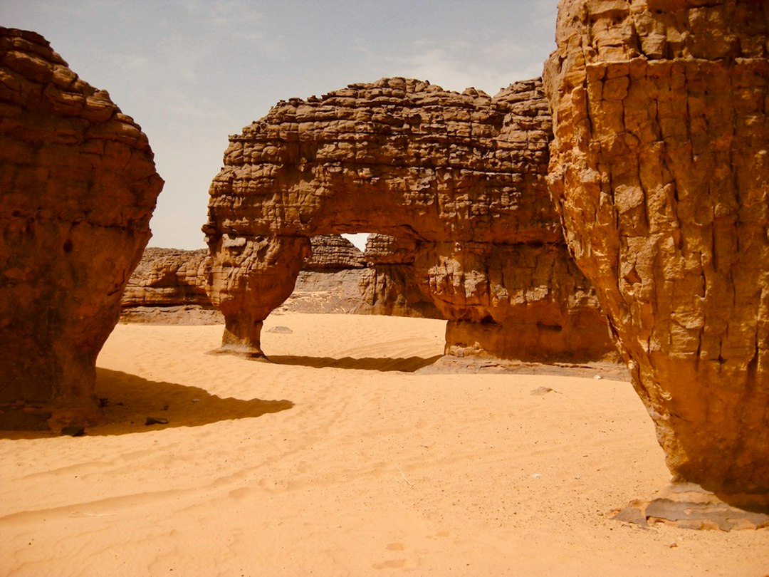 Arche de grès érodée au milieu du sable, dans le Sahara algérien