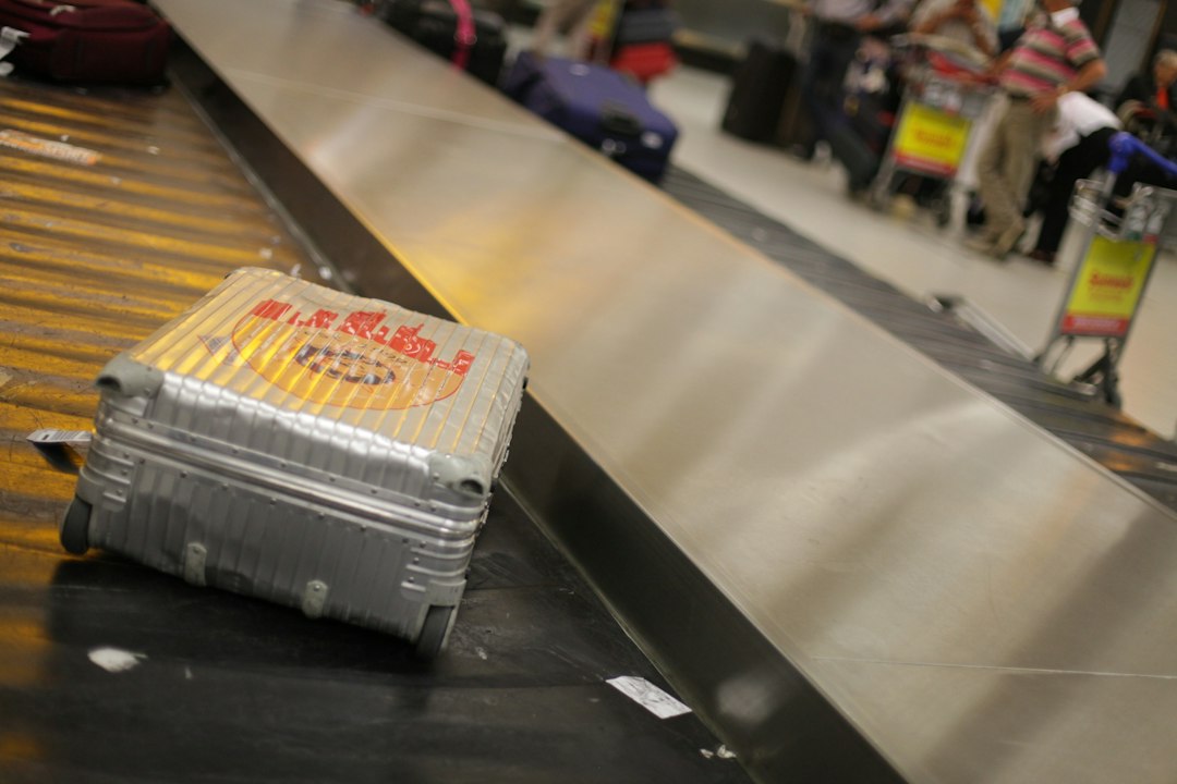 Valise rigide argentée sur le tapis de livraison des bagages d'un aéroport