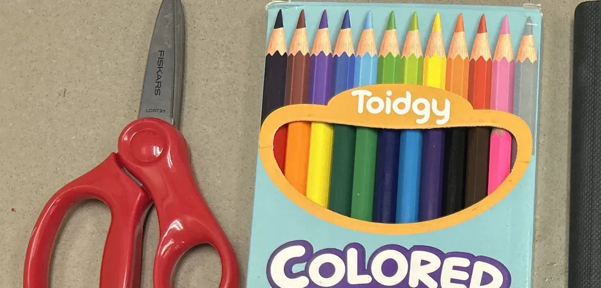 Ciseaux rouges et boîte de crayons de couleur, fournitures scolaires