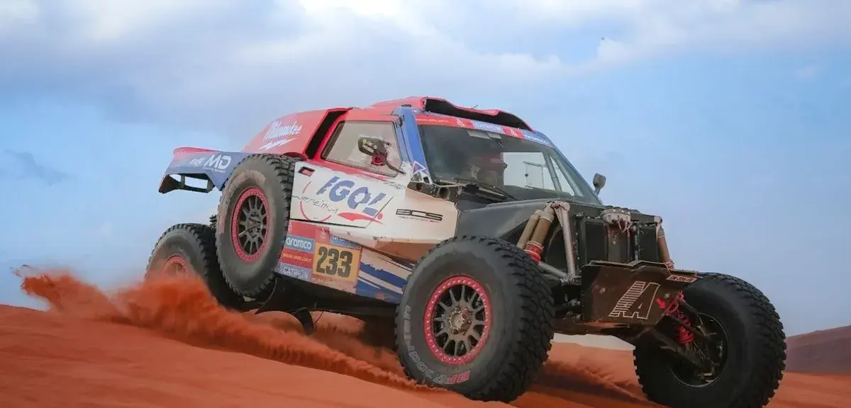 Un buggy de rallye-raid en pleine course dans les dunes rouges du désert, lors d'une édition précédente du Dakar