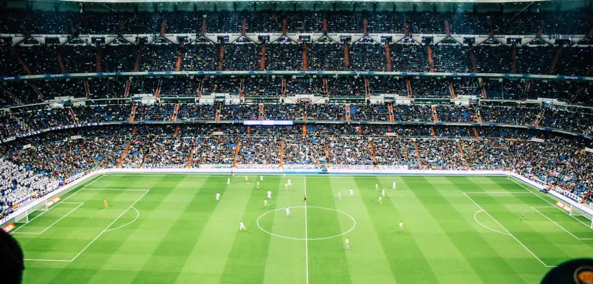 Stade de football vu depuis les tribunes lors d'un match en soirée