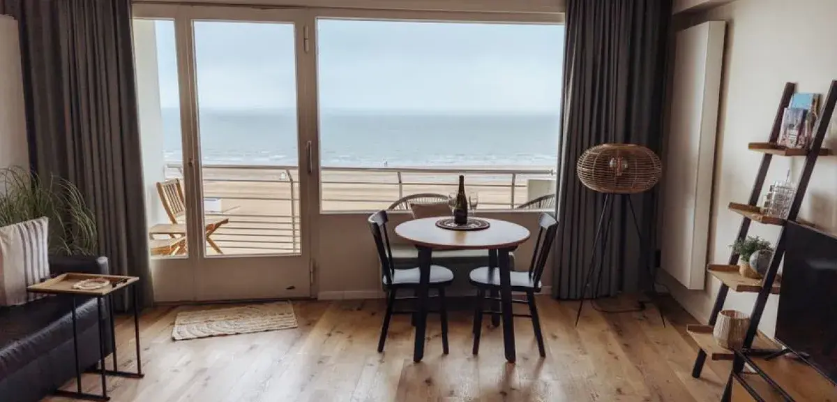 Salon lumineux d'un appartement en bord de mer avec vue sur l'océan. Photo : Russell Butcher / Pexels