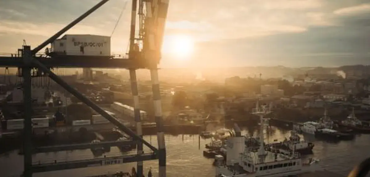 Grue et navires de charge dans un port au coucher du soleil