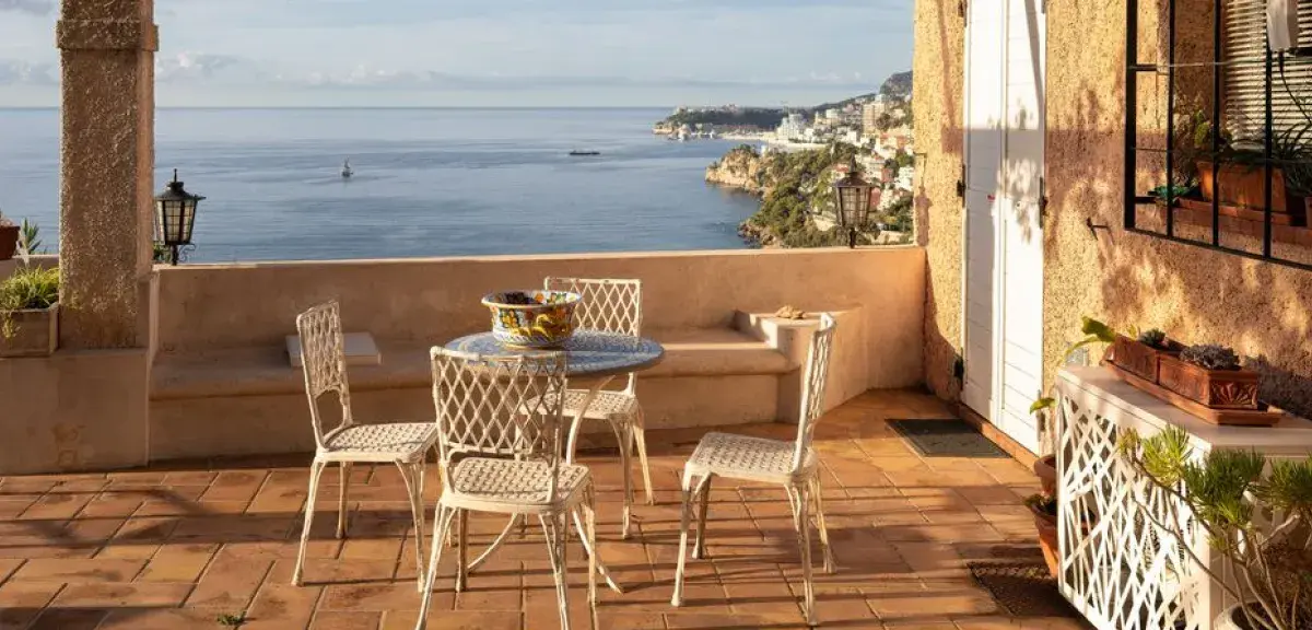 Terrasse en terre cuite avec table et chaises donnant sur la mer Méditerranée