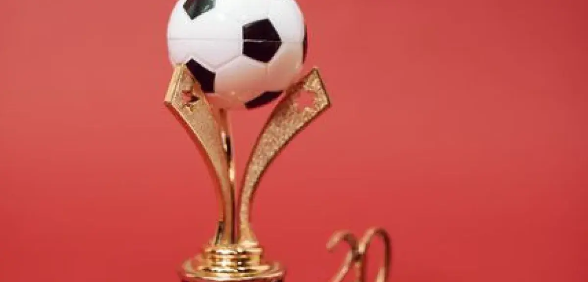 Trophée de football doré surmonté d'un ballon