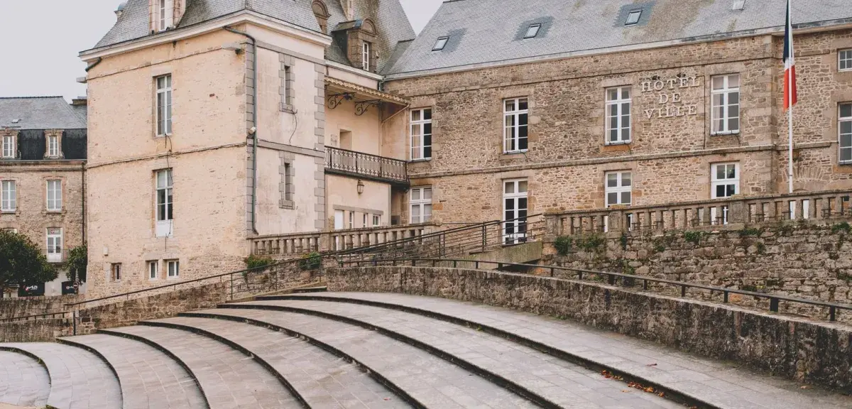 Façade en pierre de l'hôtel de ville de Dinan, avec le drapeau français