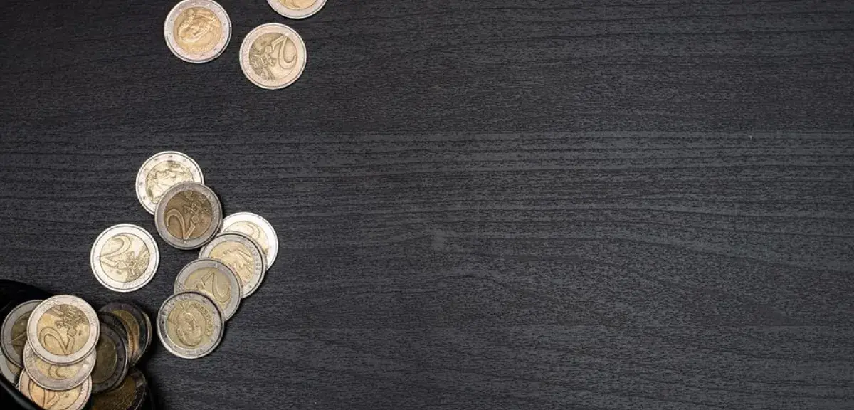 Pièces en euros disposées sur une surface sombre pour illustrer l'épargne