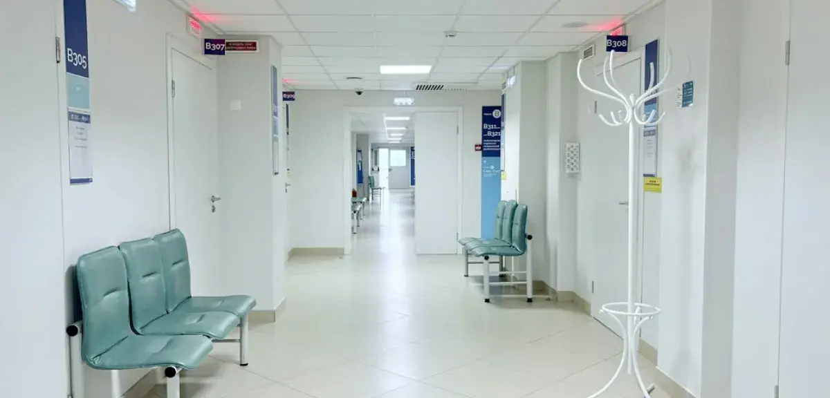 Couloir d'hôpital vide avec bancs et portes
