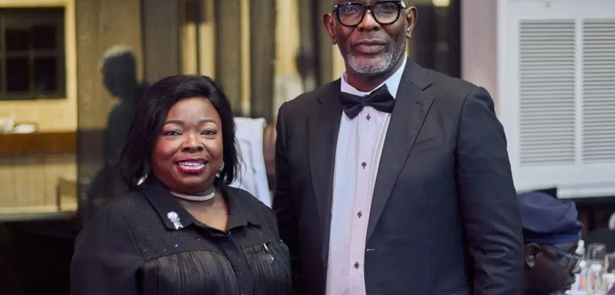 Deux invités en tenue de soirée souriants lors d'un événement de gala