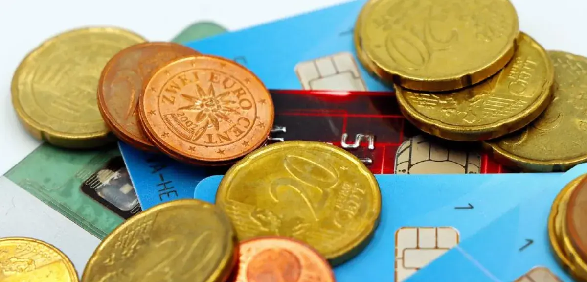 Pièces de monnaie en euros posées sur des cartes bancaires