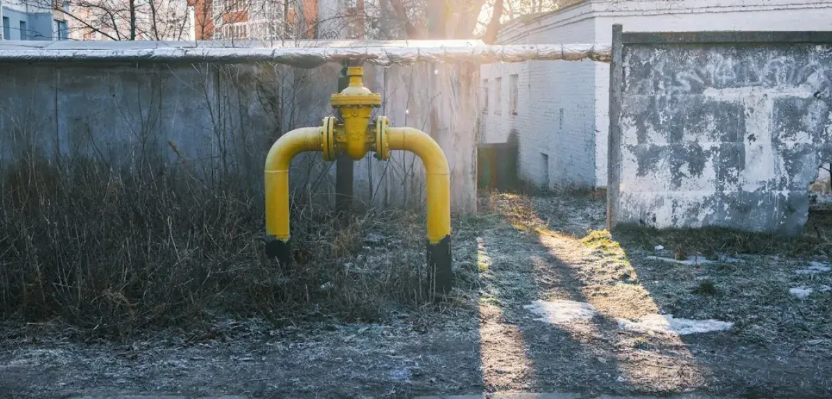 Conduite de gaz jaune avec vanne sur un mur en béton