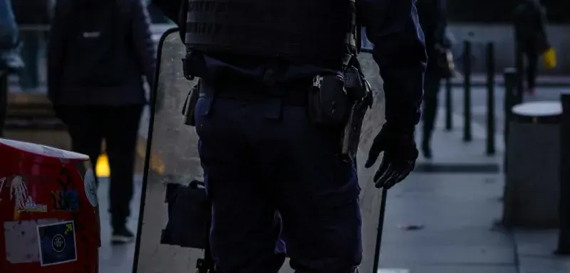 police officer standing and carrying riot shield