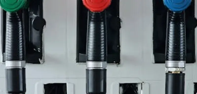 Pistolets de pompe à carburant verts, rouges et bleus dans une station-service