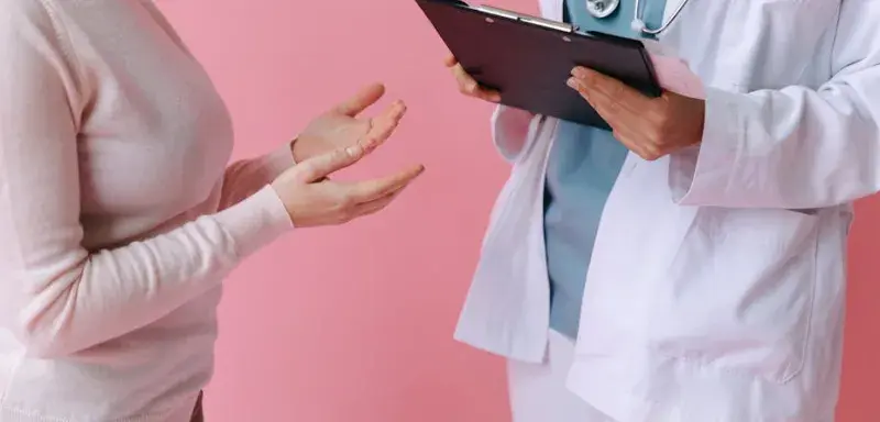 Consultation médicale entre un patient et un médecin tenant un dossier médical