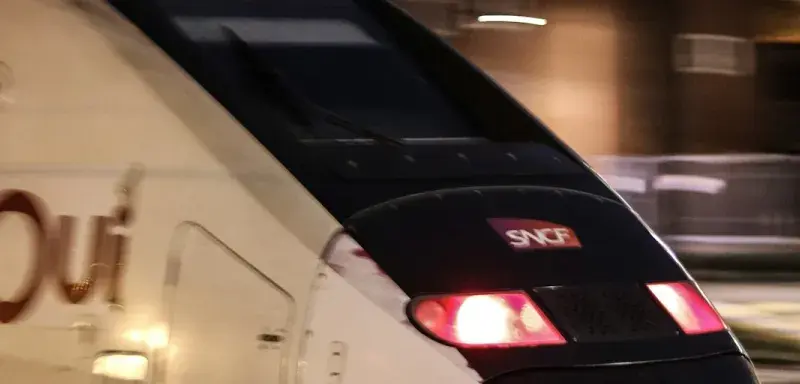 Train blanc circulant sur les rails la nuit