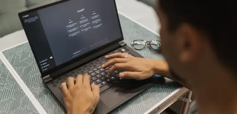 Une personne utilisant un ordinateur portable pour interagir avec une technologie d'intelligence artificielle