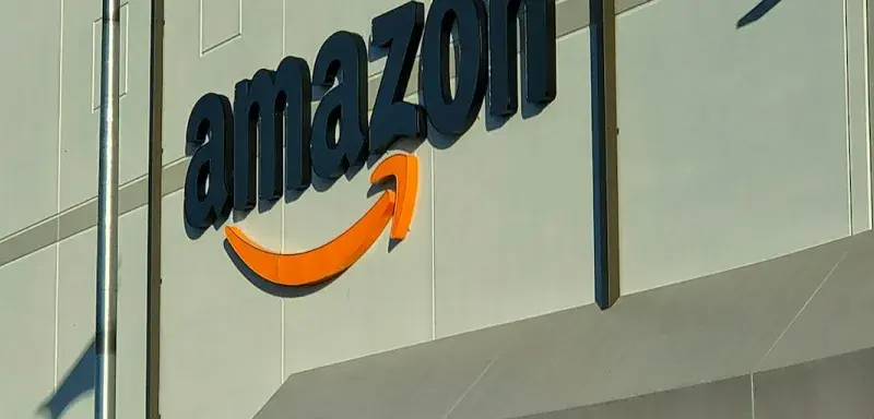Devanture d'un magasin Amazon avec une personne assise devant