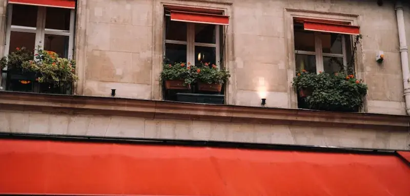 Façade d'un immeuble parisien typique avec ses balcons en fer forgé dans un cadre urbain