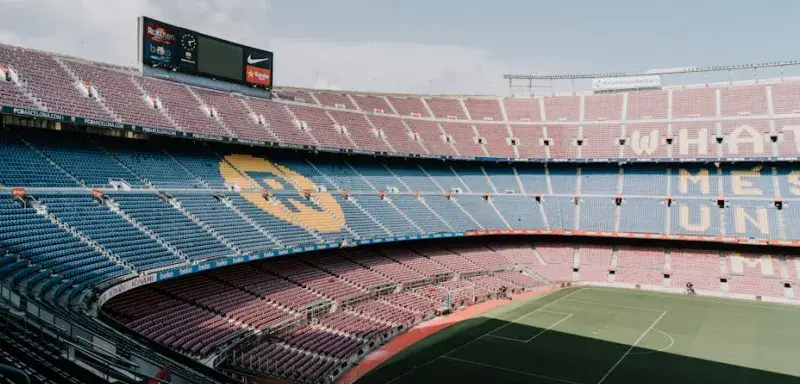 Vue du stade Camp Nou à Barcelone, mettant en avant les tribunes emblématiques et le terrain