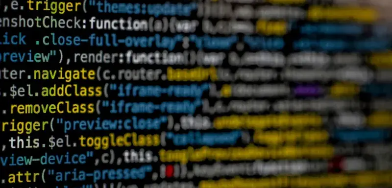 Écran affichant du code informatique en jaune et bleu, symbole de cyberattaque