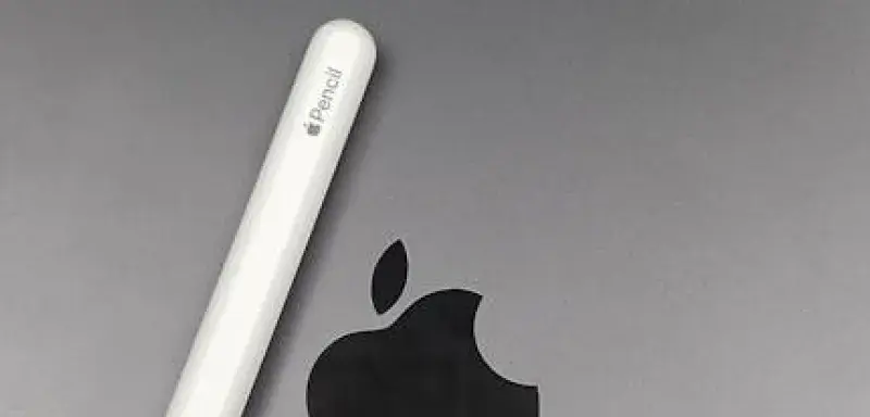 Gros plan sur un Apple Pencil posé sur un MacBook, illustrant les accessoires technologiques Apple