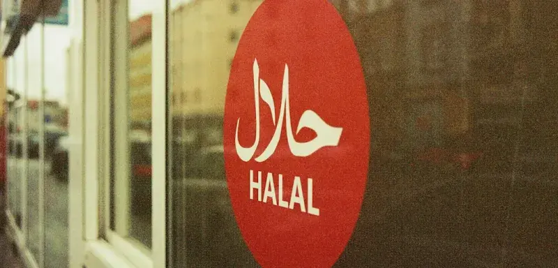 Panneau halal rouge et blanc dans un commerce alimentaire
