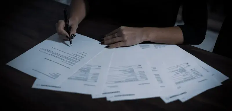 Une femme assise à une table avec de nombreux documents