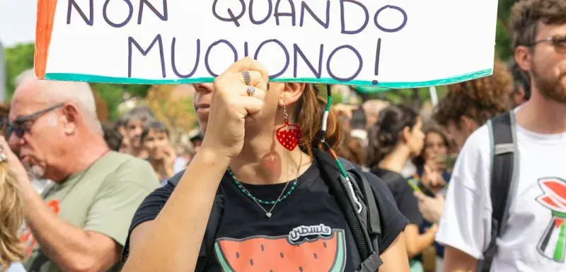 Manifestante brandissant une pancarte lors d'une protestation contre la politique migratoire en Italie