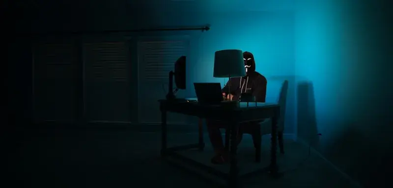 man sitting facing laptop — cybersécurité