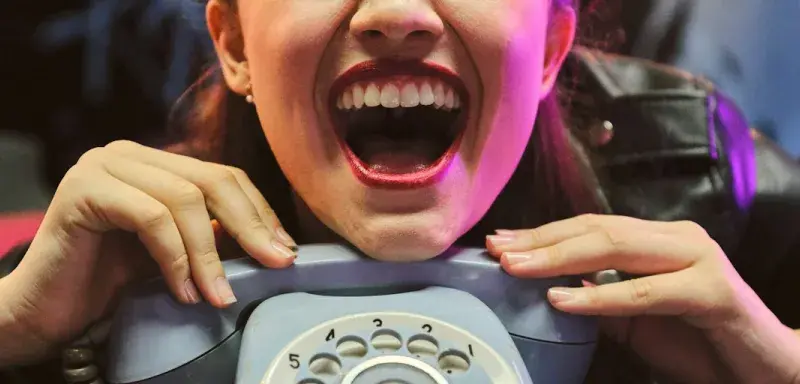 girl holding gray rotary-dial telephone