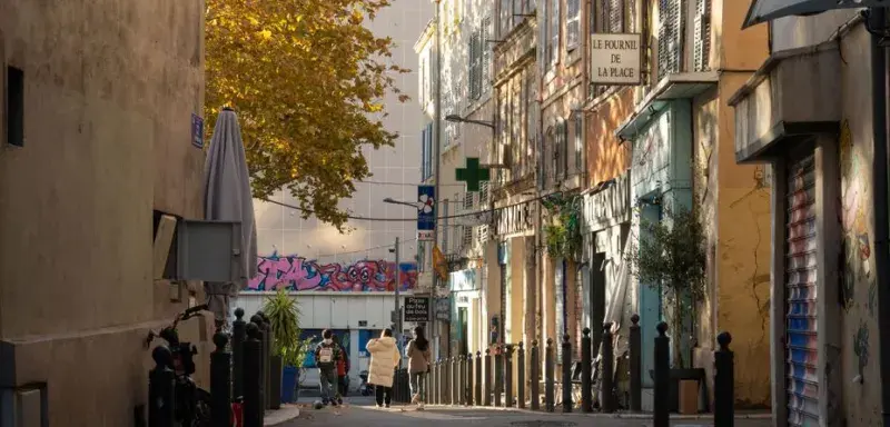Idyllic street view with people walking in the warm glow of Marseille, capturing urban charm and local life.