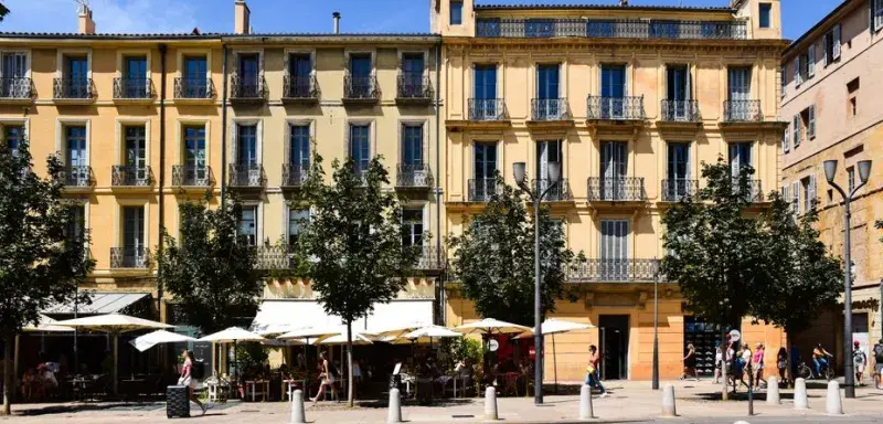 Sunny day in Aix-en-Provence with classic French architecture and bustling street life.