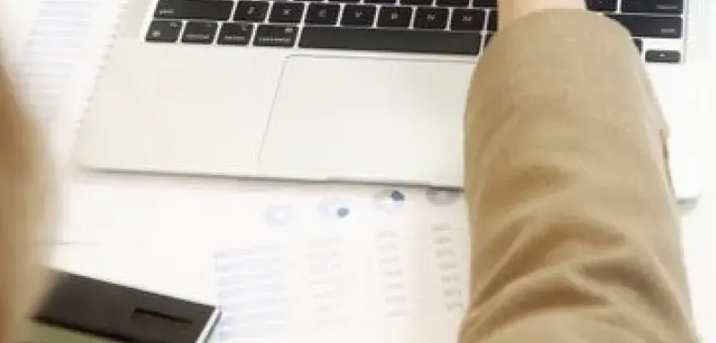 Business professional analyzing financial data on a laptop for strategic decision making.