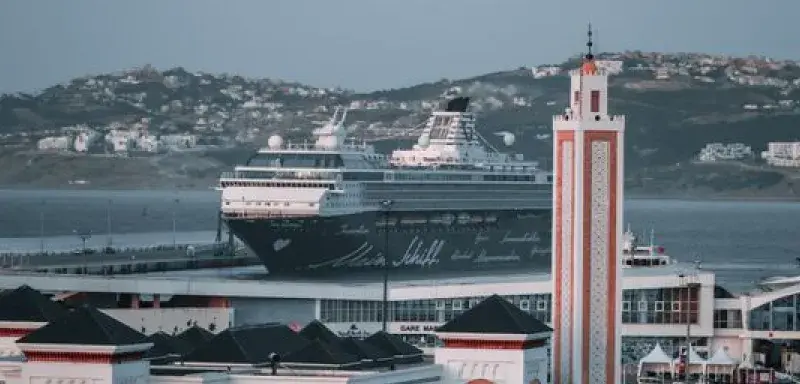Ambient cityscape of Tangier featuring a cruise ship and unique Moroccan architecture.