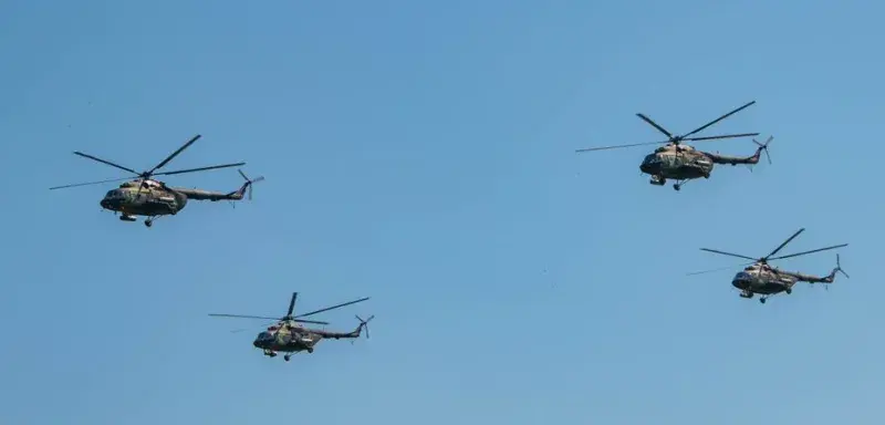 Four military helicopters flying in formation against a clear blue sky in Belgrade, Serbia.