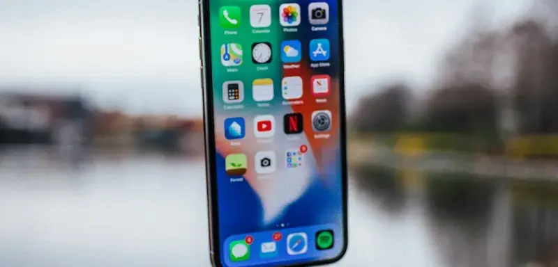 silver iPhone X floating over open palm
