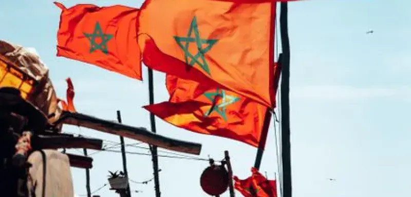 Colorful Moroccan flags waving by the ocean, symbolizing national pride and coastal culture.