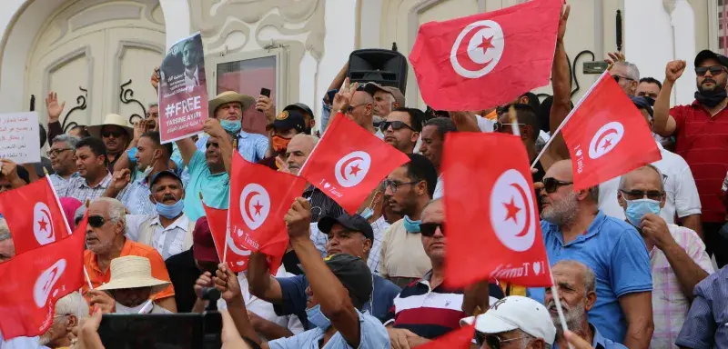a large group of people holding flags in front of a building