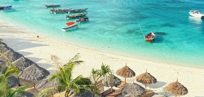 Barques en bois sur une eau turquoise le long d une plage de sable