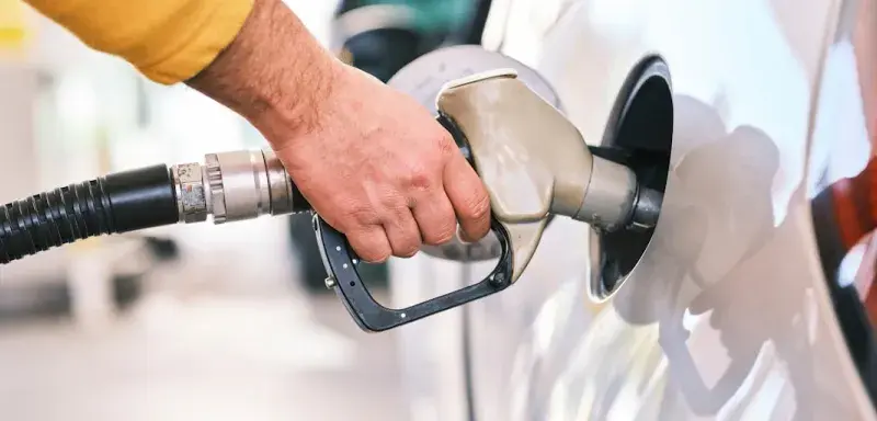 a man pumping gas into his car at a gas station
