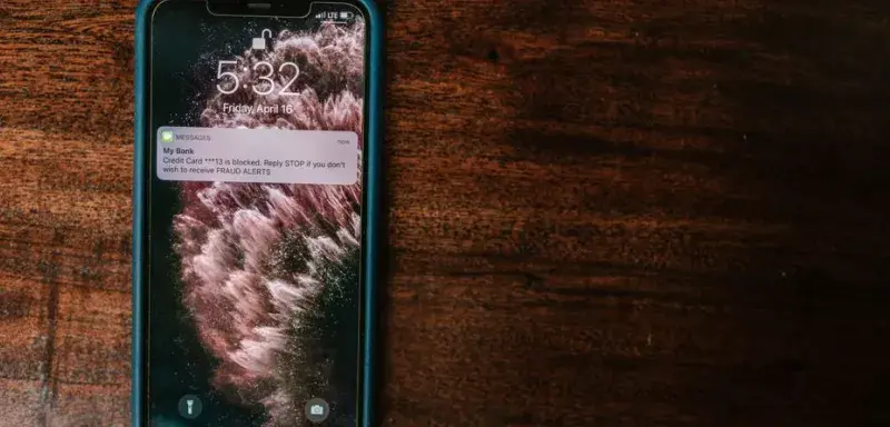 Smartphone posé sur une table affichant une alerte de la banque