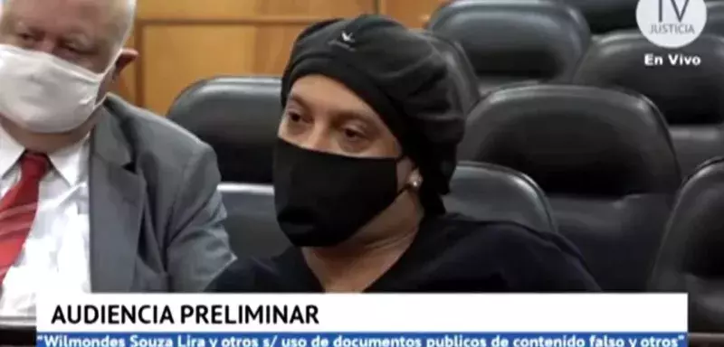 Ronaldinho, qui portait un t-shirt noir, un chapeau et un masque au tribunal, est resté sans expression et les bras croisés après le jugement. Ronaldinho, qui portait un t-shirt noir, un chapeau et un masque au tribunal, est resté sans expression et les bras croisés après le jugement.