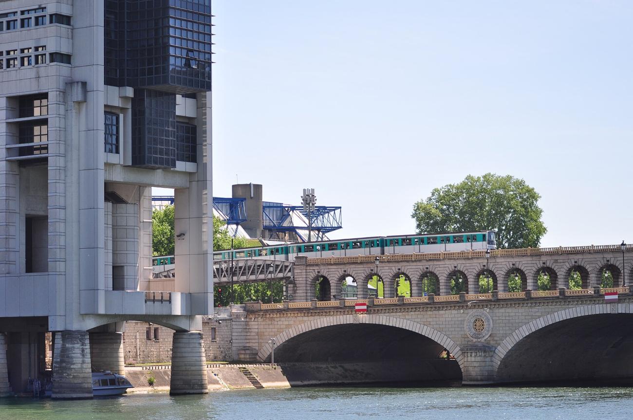 Le bâtiment Colbert du ministère de l'Économie et des Finances à Bercy, au bord de la Seine, avec le pont de Bercy et une rame de métro