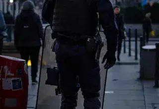 police officer standing and carrying riot shield