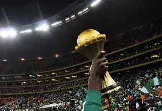 Un joueur nigérian brandit le trophée de la Coupe d'Afrique des nations dans un stade en liesse à Johannesburg