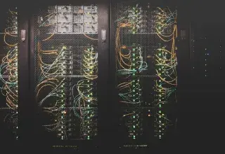 Salle de serveurs d'un data center avec rangées d'équipements informatiques éclairés en bleu